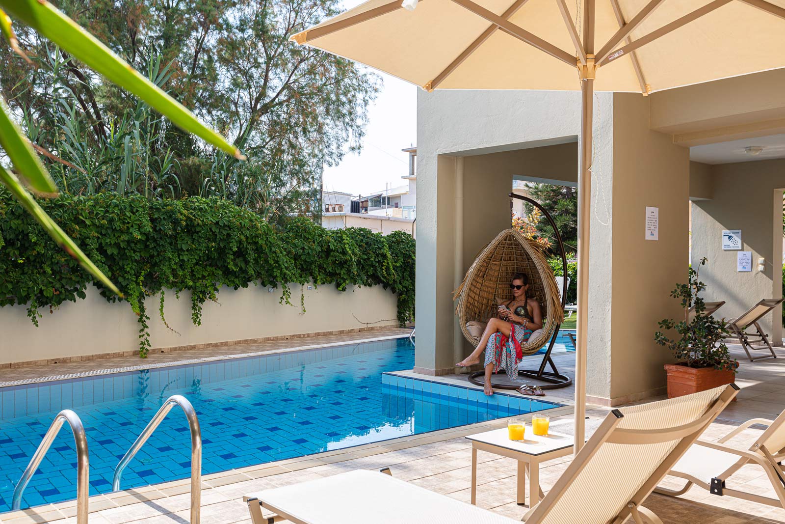 Woman reading book, sitting by the pool